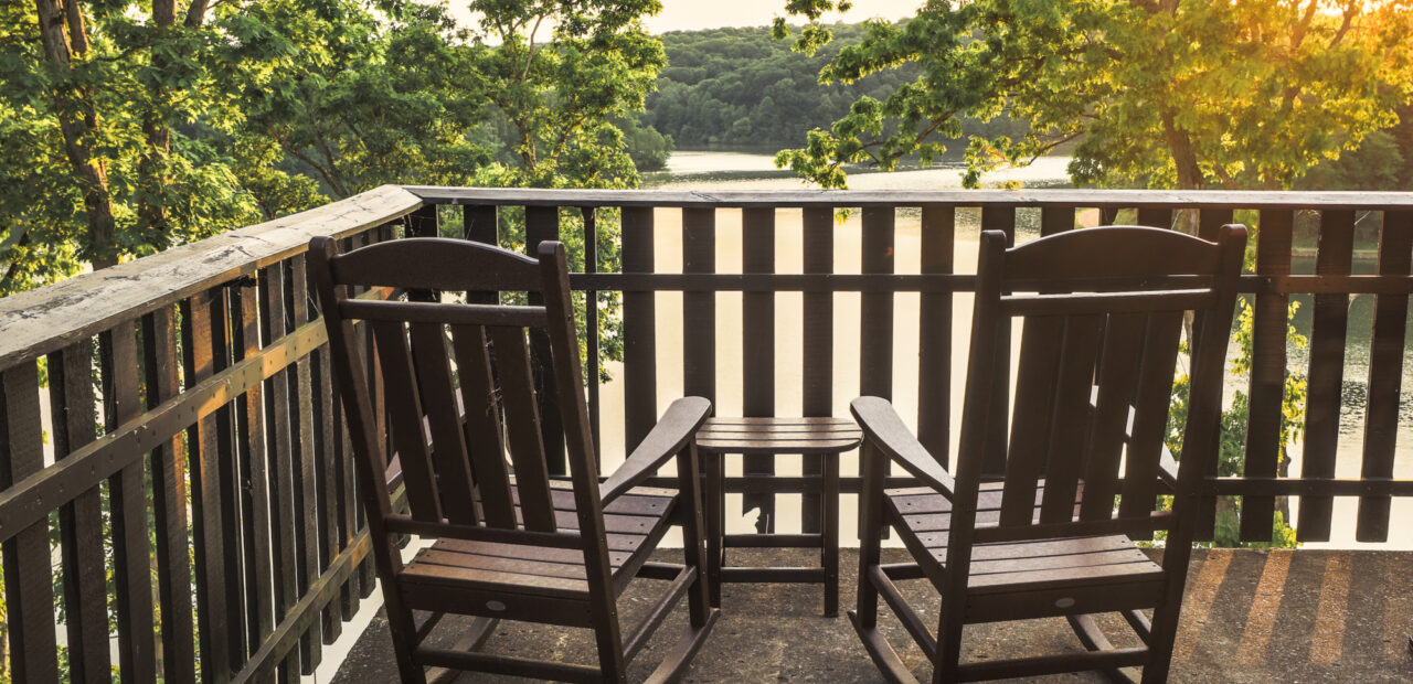 two rocking chairs on porch overlooking lake