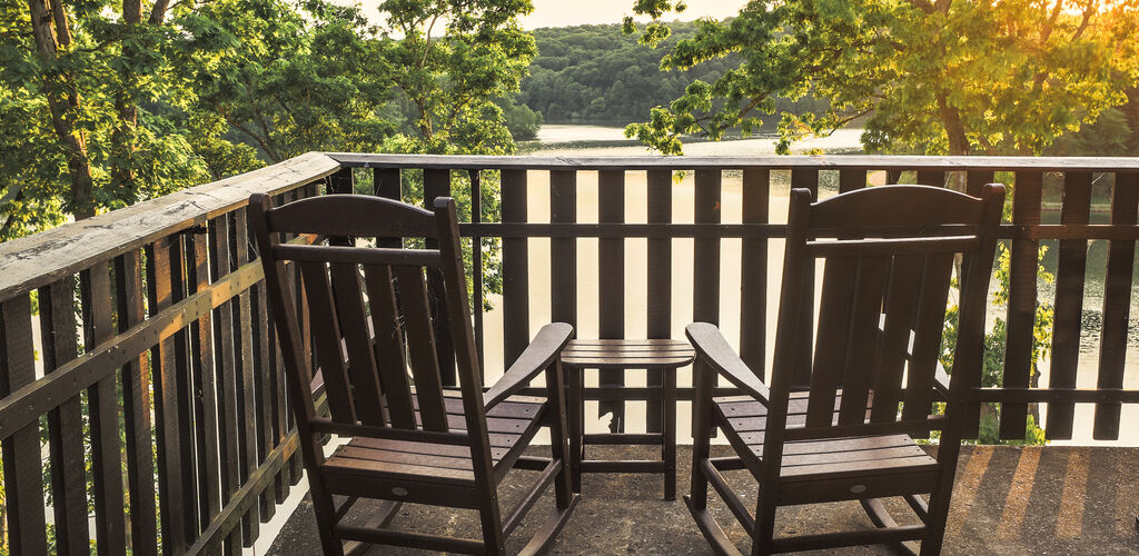two rocking chairs on porch overlooking lake